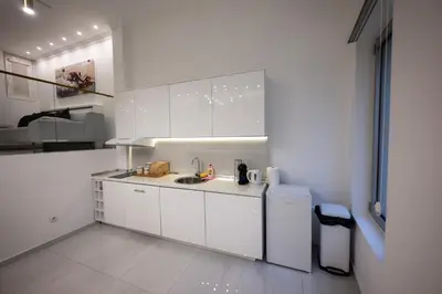 a white kitchen with a sink and a refrigerator at Aries apartment in Belgrade in Belgrade