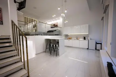 a large white kitchen with a bar and a counter at Aries apartment in Belgrade in Belgrade