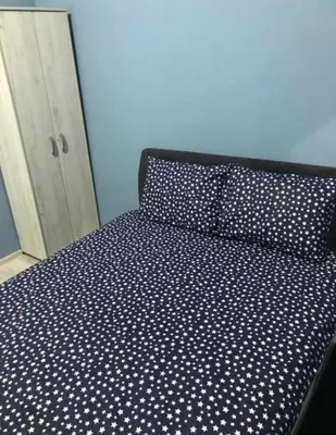 a bed with a blue and white polka dot sheets at Fine Plus in Belgrade
