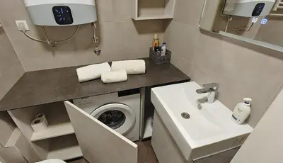 a bathroom with a washing machine and a sink at Arena Lux apartment in Belgrade