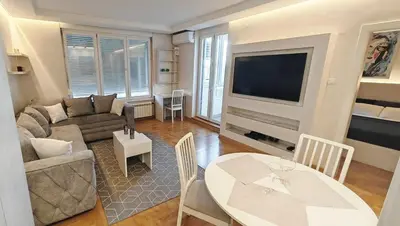 a living room with a couch a table and a tv at Arena Lux apartment in Belgrade