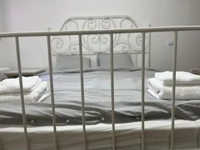 a metal bed with towels stacked on it at Costa apt 3 bedrooms Ideal for Groups Near Arena in Belgrade