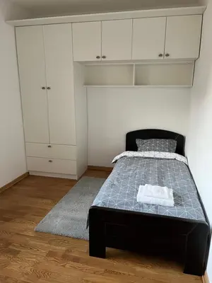 a bedroom with a bed and white cabinets at Costa apt 3 bedrooms Ideal for Groups Near Arena in Belgrade