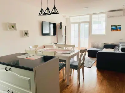 a kitchen and living room with a table and chairs at Costa apt 3 bedrooms Ideal for Groups Near Arena in Belgrade
