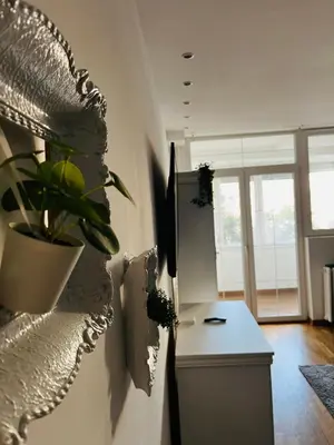 a kitchen with a table and a plant on the wall at Costa apt 3 bedrooms Ideal for Groups Near Arena in Belgrade
