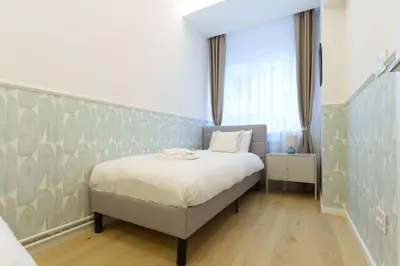 a bedroom with a bed and a large window at Elysian in Belgrade