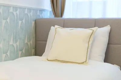 a bed with a white pillow on top of it at Elysian in Belgrade