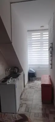 a small kitchen with a sink and a window at Small apartment with private bathrooms STRONG INTERNET in Belgrade