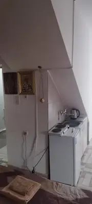 a kitchen with a stove and a white refrigerator at Small apartment with private bathrooms STRONG INTERNET in Belgrade