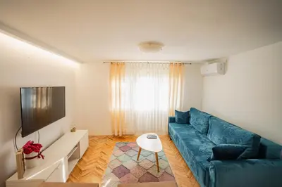 a living room with a blue couch and a tv at VP apartment in Belgrade
