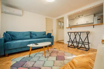 a living room with a blue couch and a table at VP apartment in Belgrade