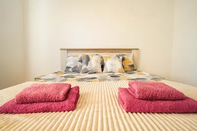 two pink pillows sitting on top of a bed at VP apartment in Belgrade