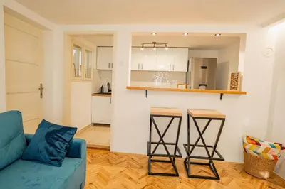 a living room with a blue couch and a kitchen at VP apartment in Belgrade
