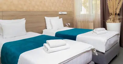 a hotel room with two beds with towels on them at Garni Hotel Mint in Belgrade