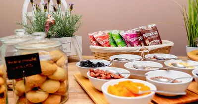 a table topped with bowls of fruit and snacks at Garni Hotel Mint in Belgrade