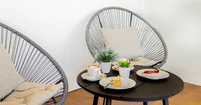 a table with cups and plates of food on it at Garni Hotel Mint in Belgrade