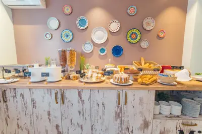 a buffet with plates and food on a table at Garni Hotel Mint in Belgrade