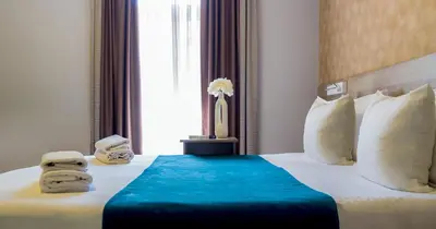a hotel room with a bed with towels on it at Garni Hotel Mint in Belgrade