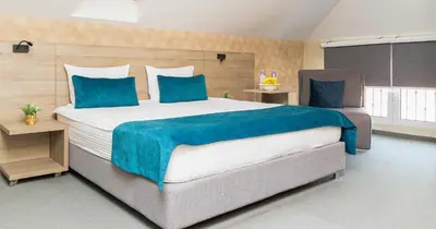 a large bedroom with a large bed with blue pillows at Garni Hotel Mint in Belgrade