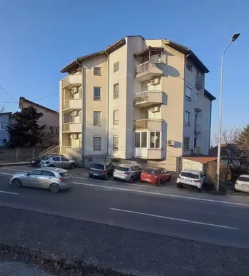a large apartment building with cars parked in front of it at Apartman Tara2 in Belgrade