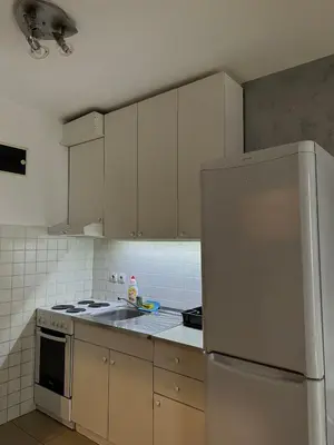 a kitchen with white cabinets and a white refrigerator at Apartman Tara1 in Belgrade