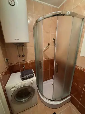 a shower stall in a bathroom with a washing machine at Apartman Tara1 in Belgrade