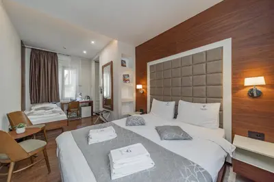 a hotel room with a large bed and a bathroom at Passpartu Garni hotel Rooms in Belgrade
