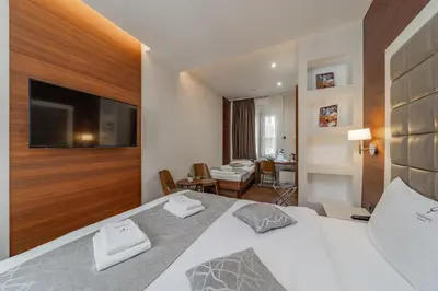a hotel room with a bed and a television at Passpartu Garni hotel Rooms in Belgrade
