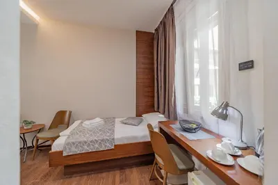 a bedroom with a bed and a table with chairs at Passpartu Garni hotel Rooms in Belgrade