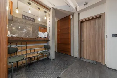 a room with a bar with chairs and a door at Passpartu Garni hotel Rooms in Belgrade
