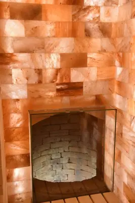 a brick fireplace in a room with a wooden wall at Passpartu Garni hotel Rooms in Belgrade