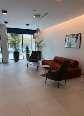 a lobby with a couch and chairs in a building at Hercules Apartment Belgrade Waterfront in Belgrade