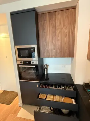 a kitchen with a black counter top with a microwave at Hercules Apartment Belgrade Waterfront in Belgrade