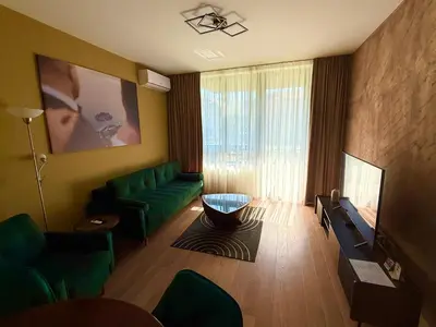 a living room with a green couch and a television at Hercules Apartment Belgrade Waterfront in Belgrade