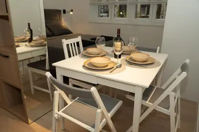 a white table with plates and wine glasses on it at Aster Apartmani in Belgrade