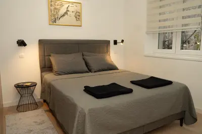 a bedroom with a bed with two black towels on it at Aster Apartmani in Belgrade