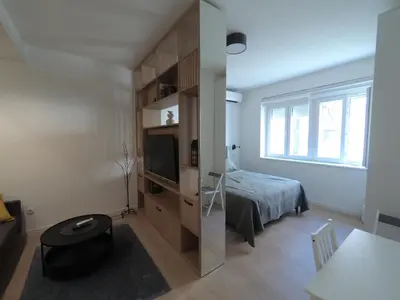 a small bedroom with a bed and a television at Aster Apartmani in Belgrade