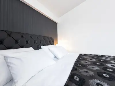 a bedroom with a large bed with white pillows at Nova City Garni Hotel Signature Collection in Belgrade