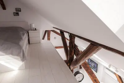 a attic bedroom with a bed and a staircase at Charming attic in the heart of the city in Belgrade
