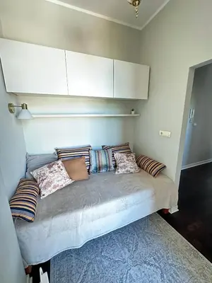 a bed with pillows on it in a room at Yulia's beautiful studio in Belgrade