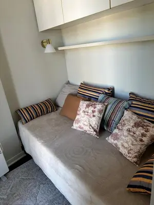 a bed in a small room with pillows on it at Yulia's beautiful studio in Belgrade