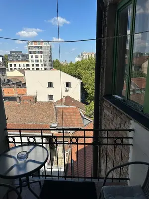a balcony with a table and a view of a city at Yulia's beautiful studio in Belgrade