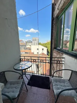 a balcony with two chairs and a table and a view at Yulia's beautiful studio in Belgrade