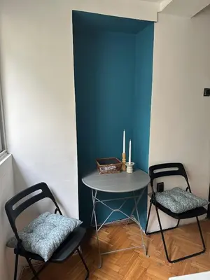 a table and two chairs in a room with a blue wall at Historic Charm Peaceful and Cozy in Belgrade