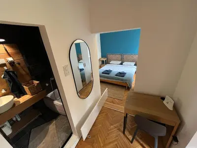 a small bathroom with a bed and a mirror at Historic Charm Peaceful and Cozy in Belgrade