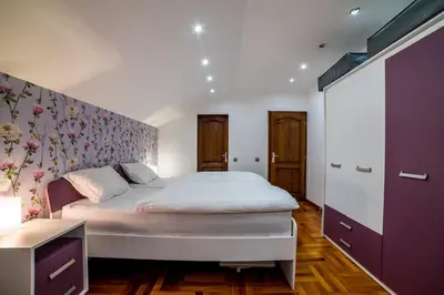 a bedroom with a large bed with a floral wall at Alrawda Resort in Mala Ivanča