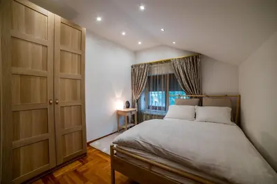 a bedroom with a large bed and a window at Alrawda Resort in Mala Ivanča