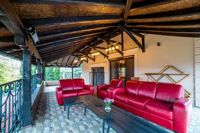a living room with red couches and a table at Alrawda Resort in Mala Ivanča