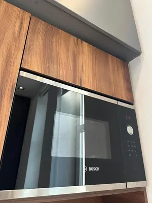 a microwave oven in a wooden cabinet at Riverside Heritage Lux and Modern 3 in Belgrade