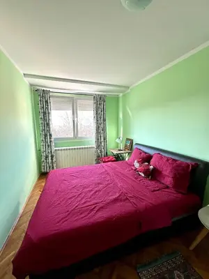 a bedroom with a large bed with a red blanket at Urban Panorama in Belgrade